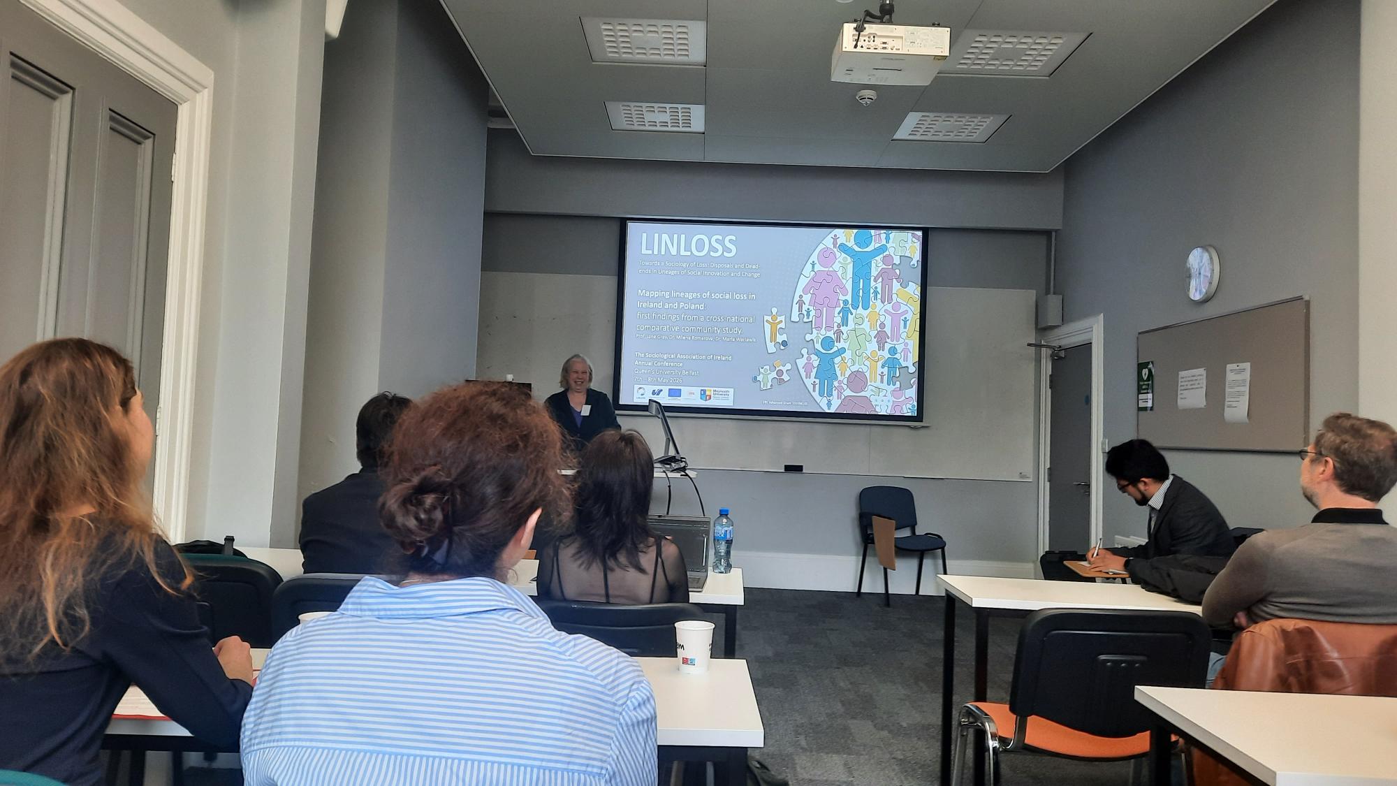 Prof Jane Gray presenting with graphics behind her